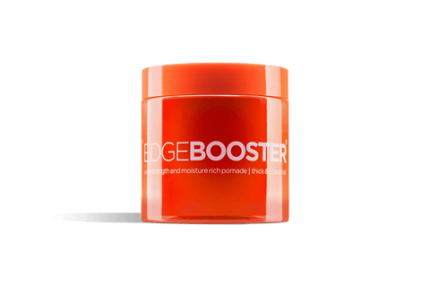 A bright orange jar of Edge Booster extra strength hair pomade sits against a black background. 
